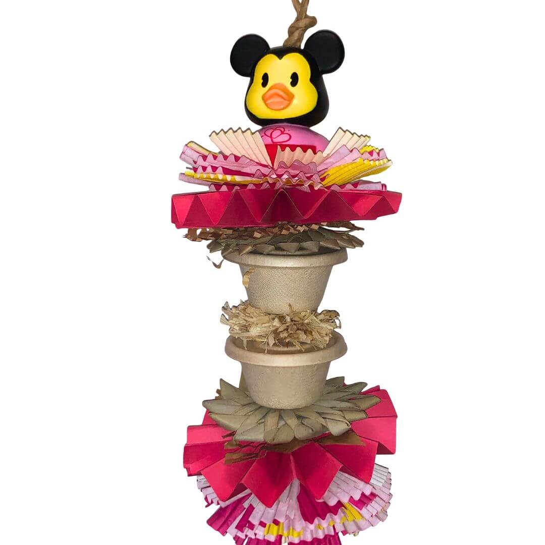 Foraging bird toy surrounded by colorful paper decorations on a white background.