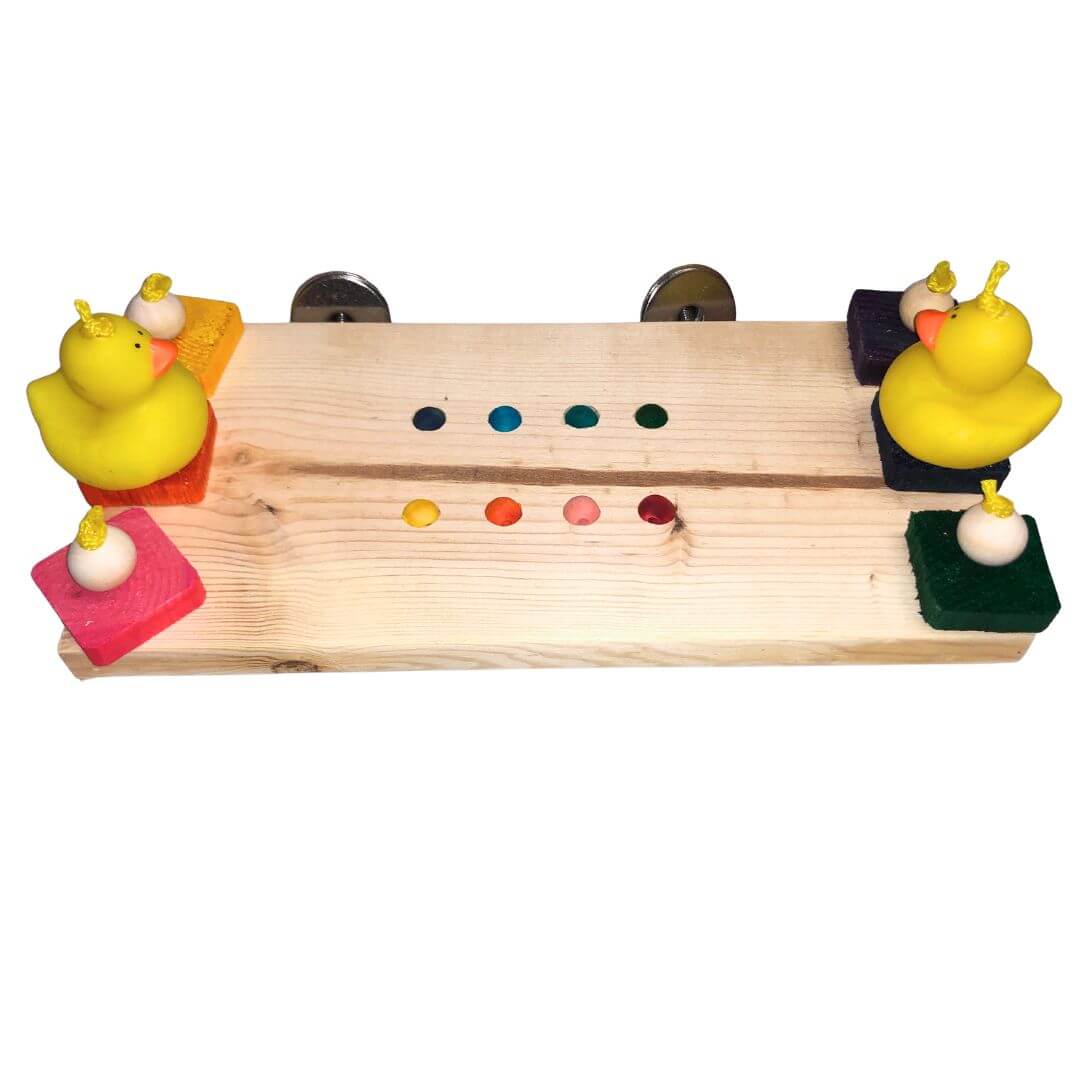 A wooden toy board with colorful painted blocks, small colored dots, and two yellow rubber ducks on a plain white background.