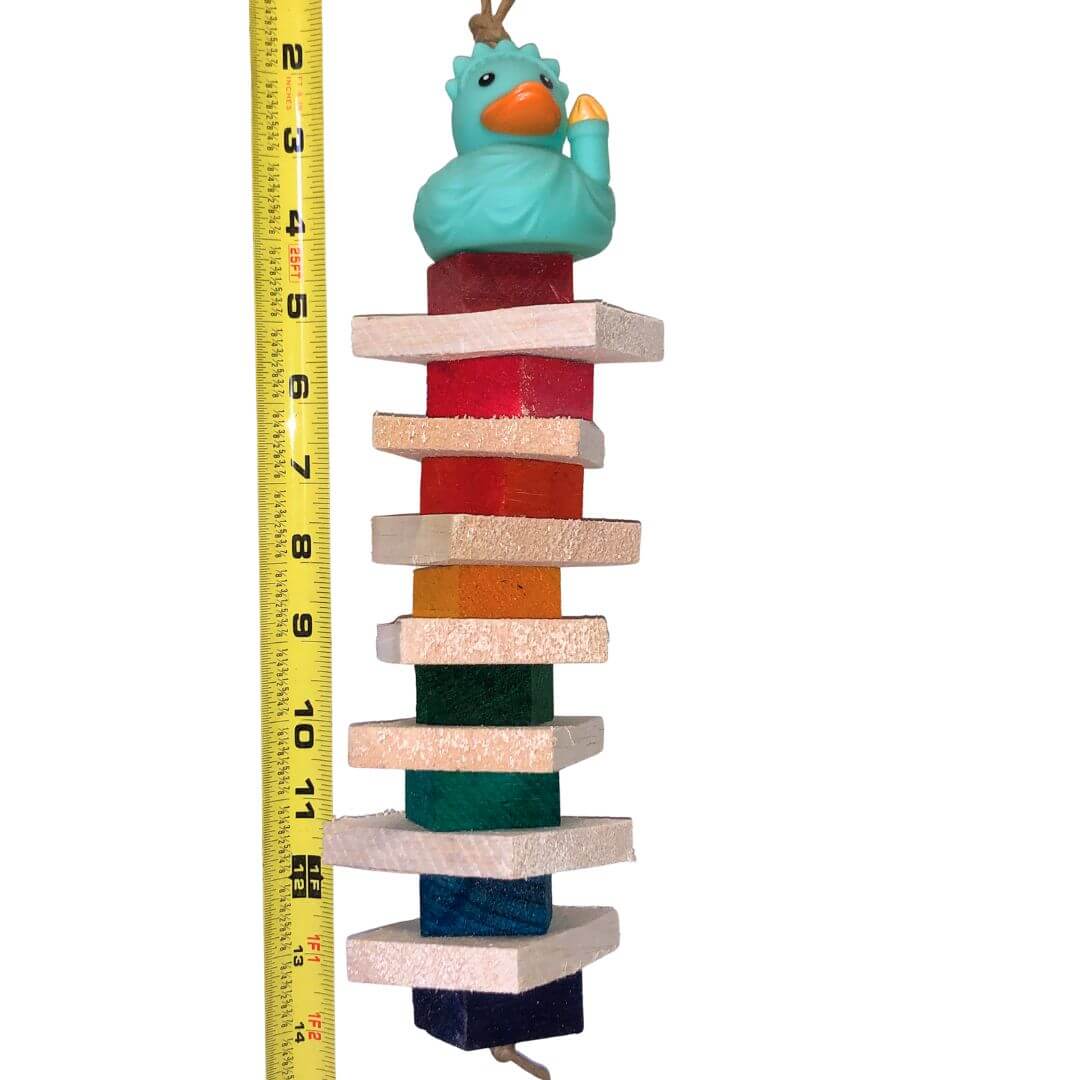 Colorful wooden block tower with a duck figure on top, next to a measuring tape for scale.
