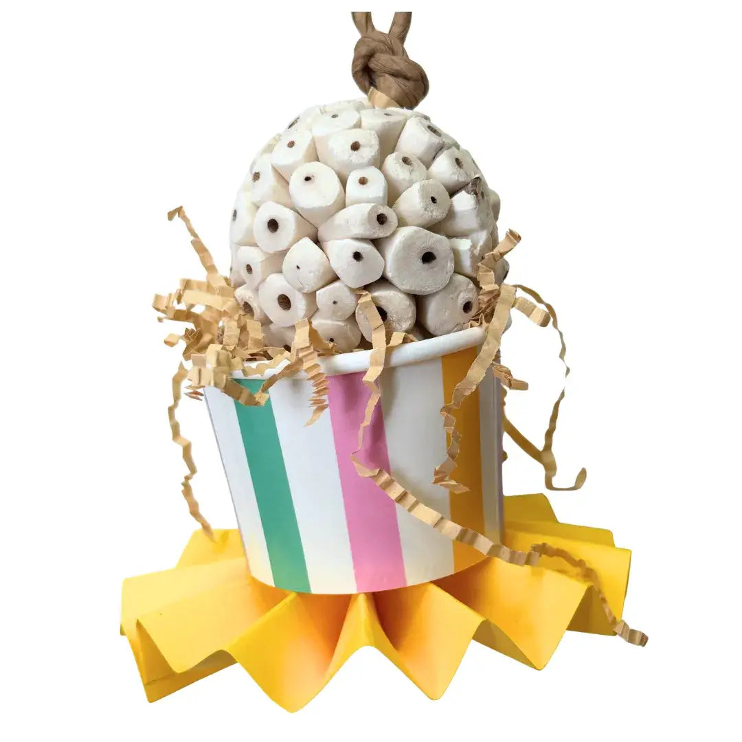A sola ball in a paper cup with pinwheel bird toy