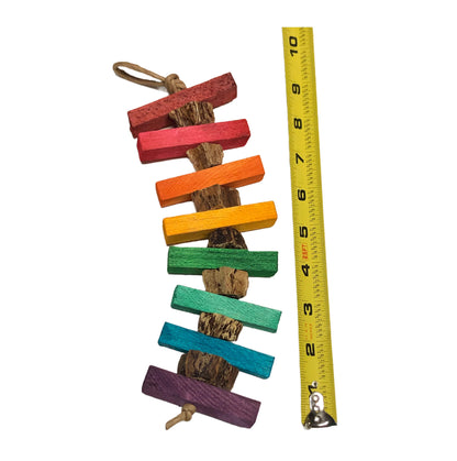 A colorful balsa wood bird toy with multiple colored sticks and a measuring tape showing the size.