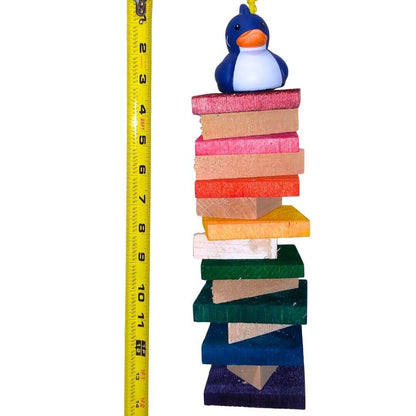 A colorful hanging bird toy made of soft balsa wood with a duck figure on top.