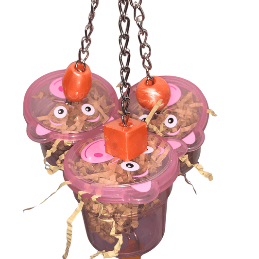 Bird toy with pink cups, orange blocks, and chain on a white background