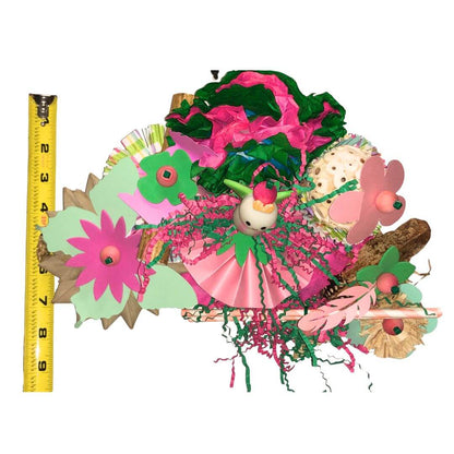 Colorful bird toy  with flowers and a bird, measured against a ruler.
